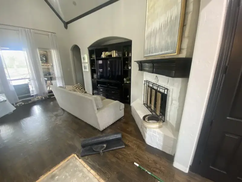 Clean dark hardwood floor in a living room with a fireplace