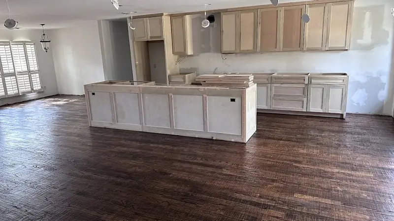 New dark hardwood floor installed through an open kitchen remodel